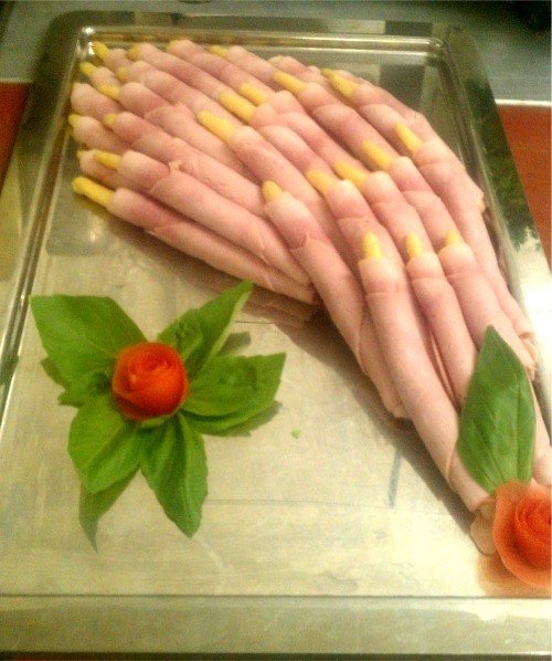 Schinkenröllchen mit Spargel auf silberner Platte